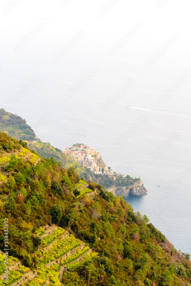 The hills of the Cinque Terre in Liguria in Italy with the human made terraces for agriculture and the small village of Corniglia in the background
