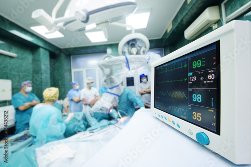 a group of surgeons operate on the patient's vital functions monitor close-up.