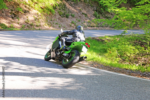 Sporty motorcyclist photographed from behind  photo