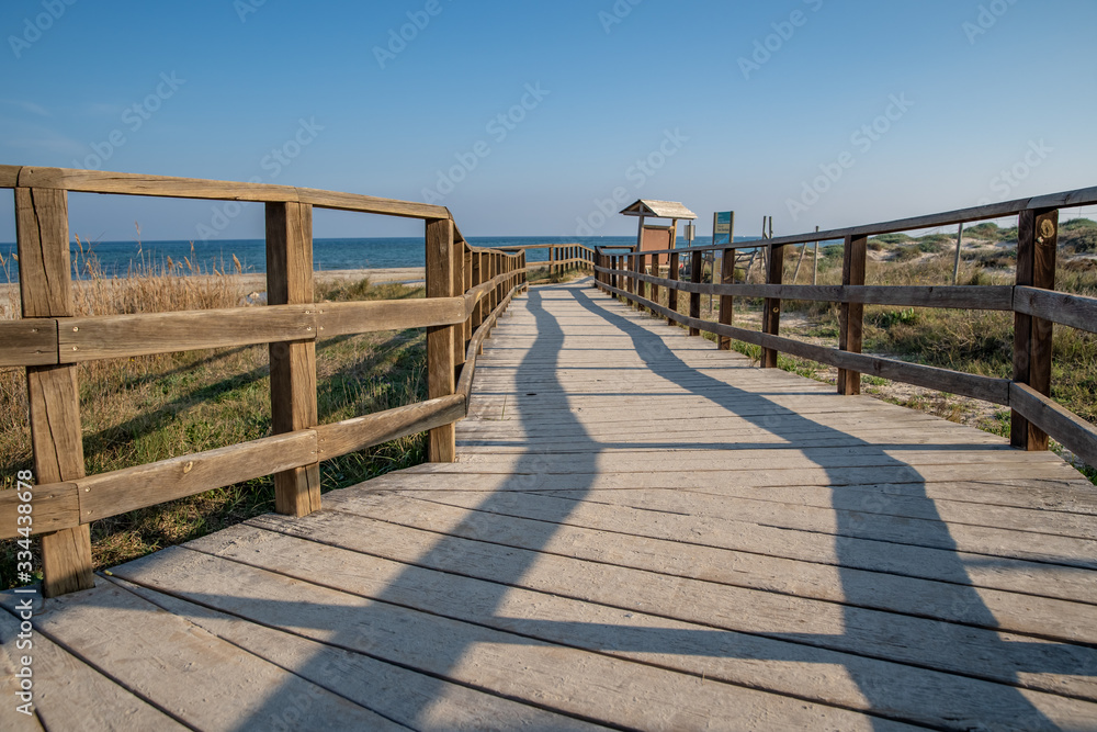wooden bridge leading along the coast to the beach