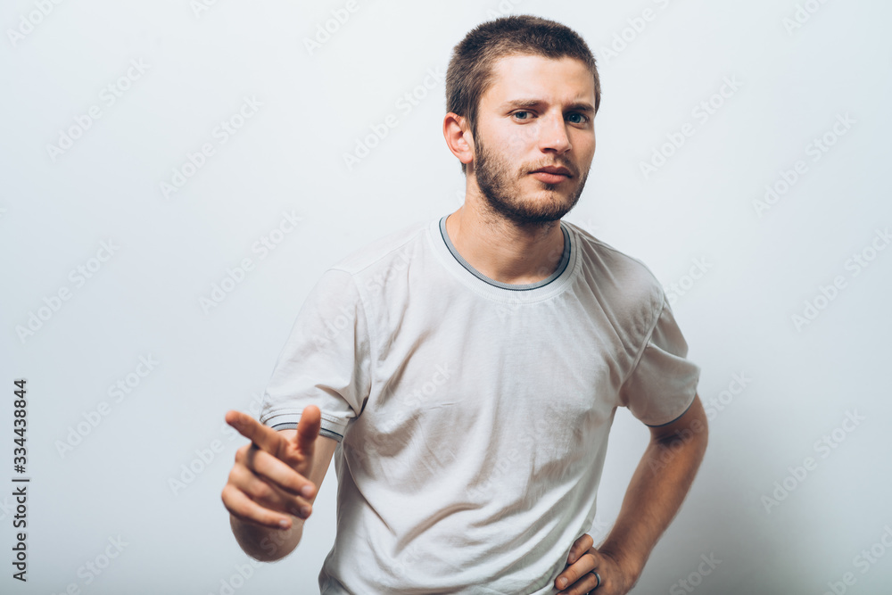 Young man showing his index finger towards the camera Young man showing his index finger towards the camera