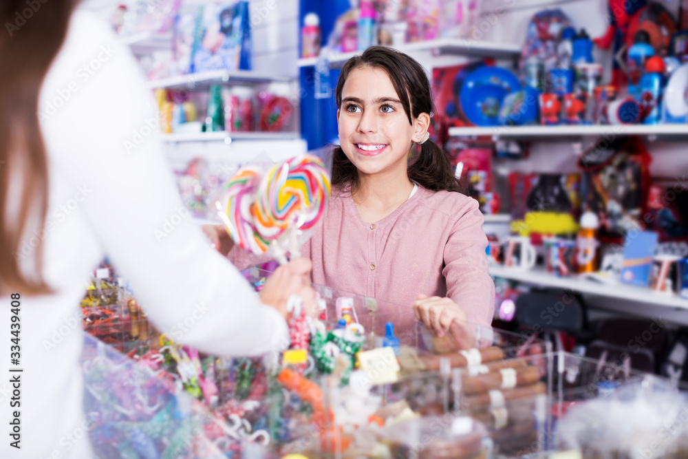 Schoolgirl buying sweet lollipop