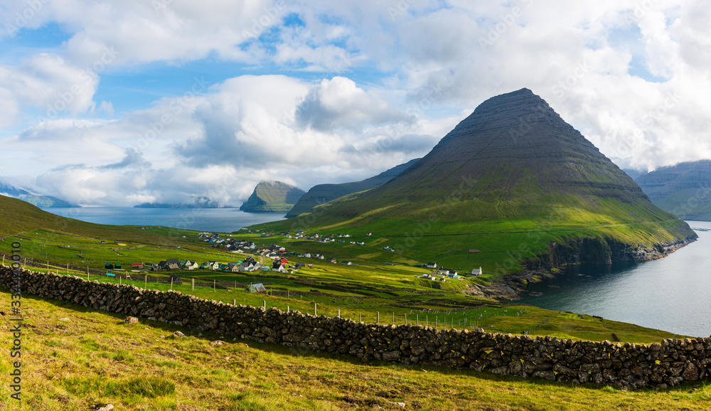 Stone wall in front of mountain landscape , Faroe Islands.