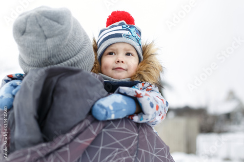 Look from behind at little boy hugging father's neck