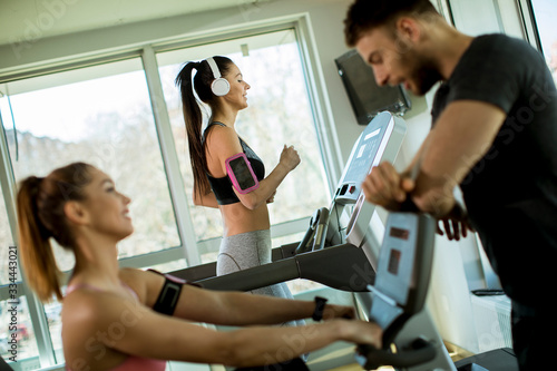 Young woman using treadmill in modern gym