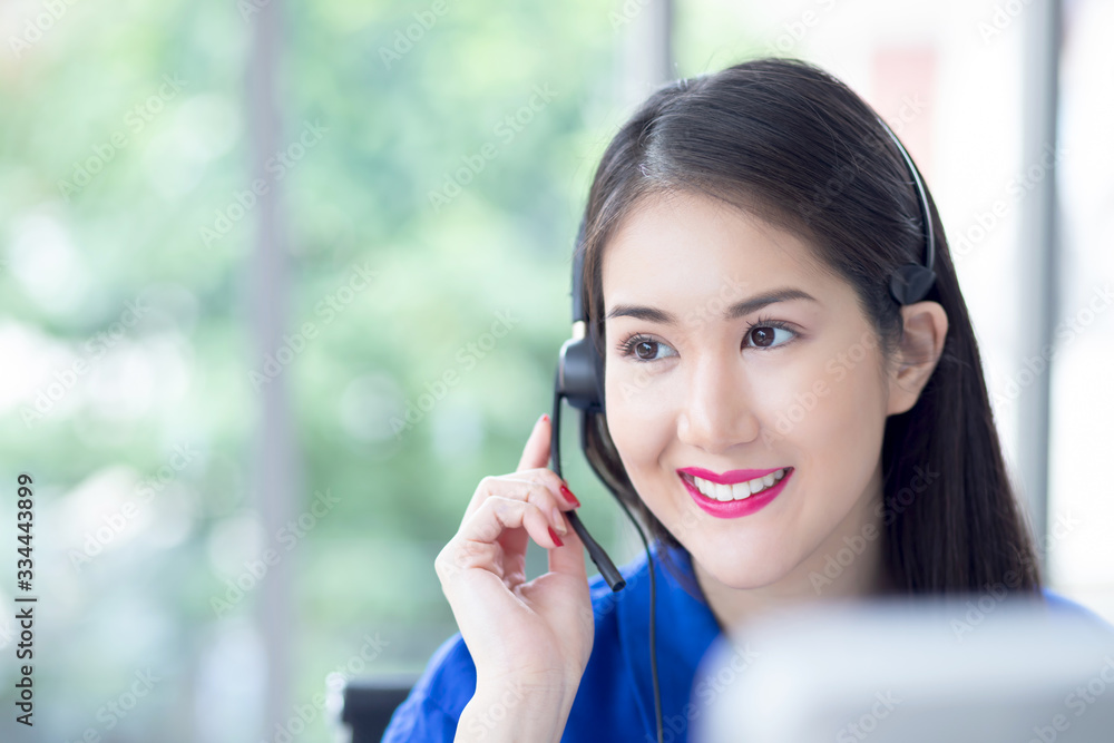 call centre. smiling friendly Beautiful face asian woman blue shirt operator working with headset look sideway front of computer screen. Technical support Customer Service agent in an startup office. call centre. smiling friendly Beautiful face asian woman blue shirt operator working with headset look sideway front of computer screen. Technical support Customer Service agent in an startup office.