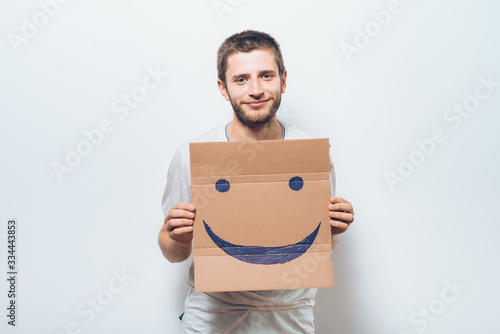 man, holding a picture with a cheerful smiley