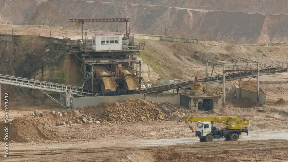 Trucks machine works in the sand ballast quarry on the cloudy summer day Trucks machine works in the sand ballast quarry on the cloudy summer day