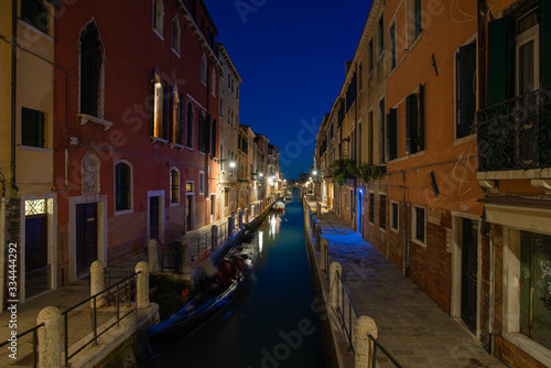 Canale illuminato di sera vicino canal grande  con case colorate a Venezia  Italia