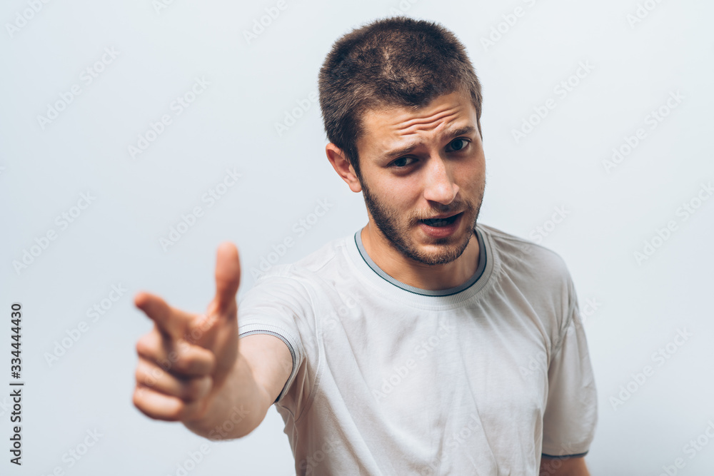 Young man showing his index finger towards the camera Young man showing his index finger towards the camera