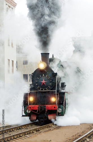 Black retro steam train. Old locomotive in motion. Railroad travel, railway tourism. Transportation. Railway oldtimer.