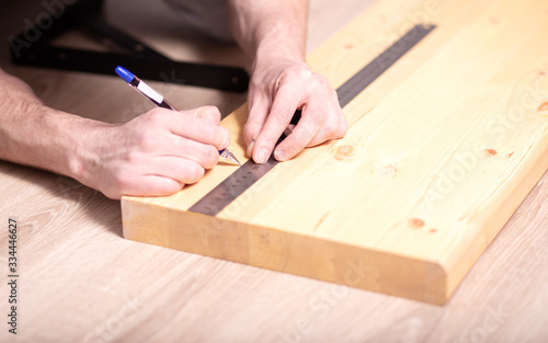 person usingmetal ruler to measure size of drilling hole to attach console. repairs on their hands,work at home concept