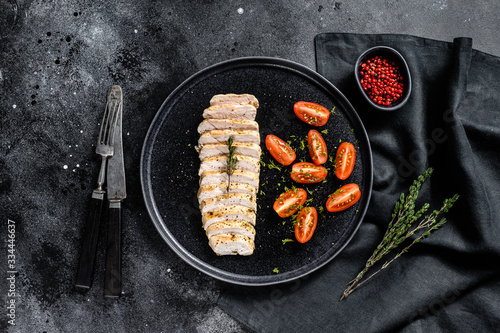 grilled chicken breast with fresh cherry tomatoes. Healthy diet food. black background. Top view