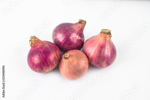 Four medium size fresh and ripe red onion isolated on a white background