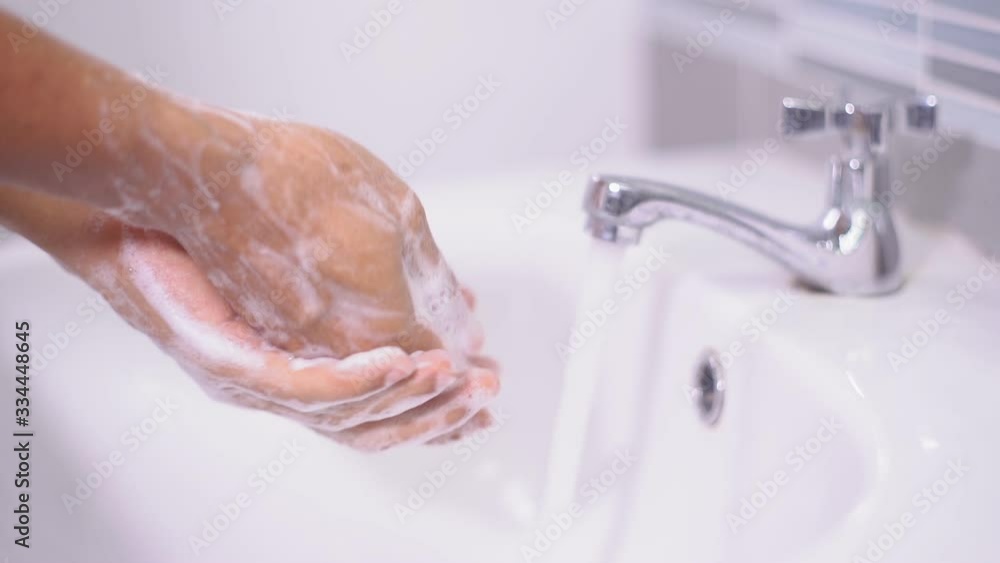Man washing male hand with soap and water under faucet at sink Inside the house to prevent infection from the coronavirus Man washing male hand with soap and water under faucet at sink Inside the house to prevent infection from the coronavirus
