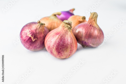 Side view of six medium size fresh and ripe red onion isolated on a white background