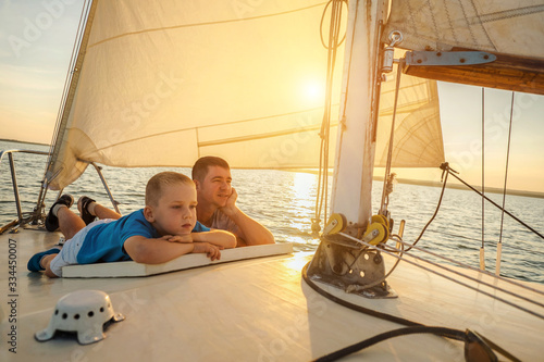 Happy traveler father and son enjoying sunset from deck of saili © Andrii IURLOV