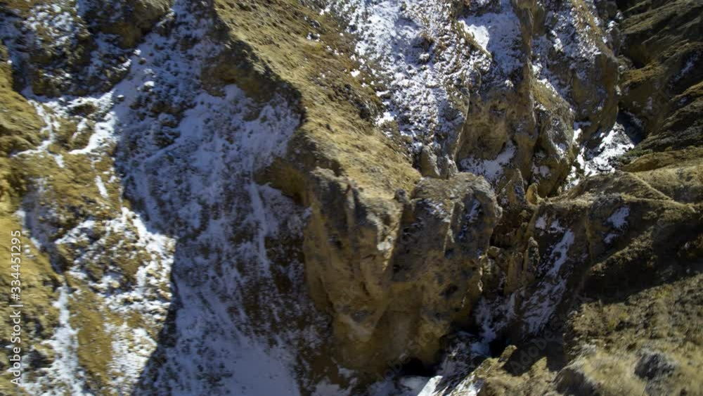 Aerial view of a mountain river and rocky mountains hills partly covered in snow in the french alps during autumn Aerial view of a mountain river and rocky mountains hills partly covered in snow in the french alps during autumn