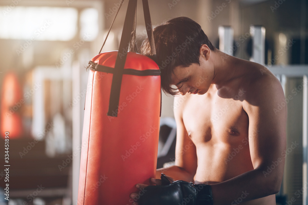 Handsome Discouraged young man exercising with boxing muscles