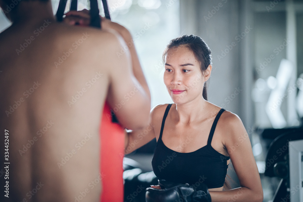 young women boxer punching bag at training fitness gym