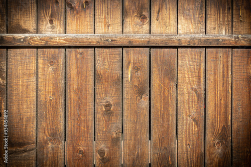  Background in grunge style. Wooden old fence with scuffs. From vertical boards of brown color. With dark vignette around the edges.