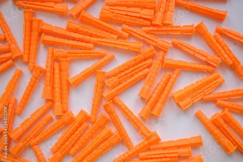 Plastic Wall Plow For backdrop. Orange color on a white background. Concept of building hardware anchor.