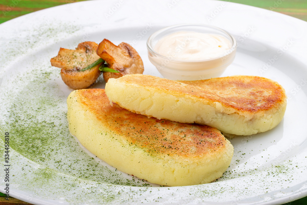 Potato zrazy with sour cream. On a colored wooden background. Vegetarian dish.