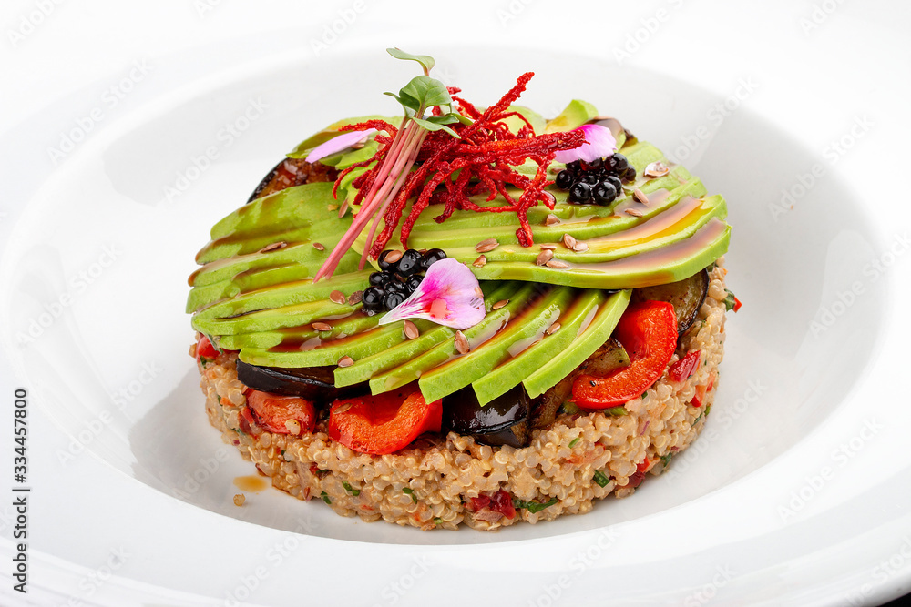 Salad with quinoa, avocado and roasted vegetables. On a colored wooden background. Vegetarian dish. Salad with quinoa, avocado and roasted vegetables. On a colored wooden background. Vegetarian dish.