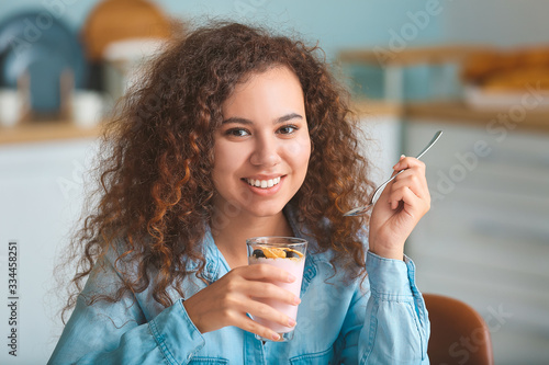 Young woman eating tasty yo...