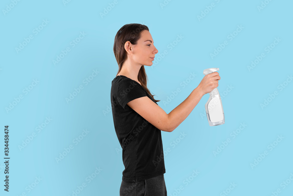 Young woman holding spray plastic bottle with cleaning liquid. Spring cleaning concept. Disinfecting Young woman holding spray plastic bottle with cleaning liquid. Spring cleaning concept. Disinfecting