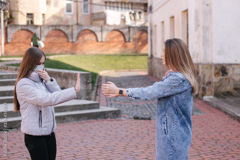 Girls in masks. Coronavirus theme. Women in the city walks during quarantine. No hugs Girls in masks. Coronavirus theme. Women in the city walks during quarantine. No hugs
