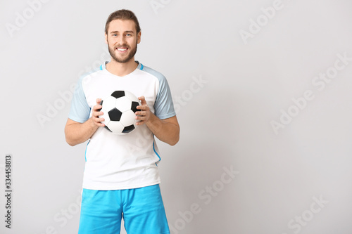 Male football player on grey background