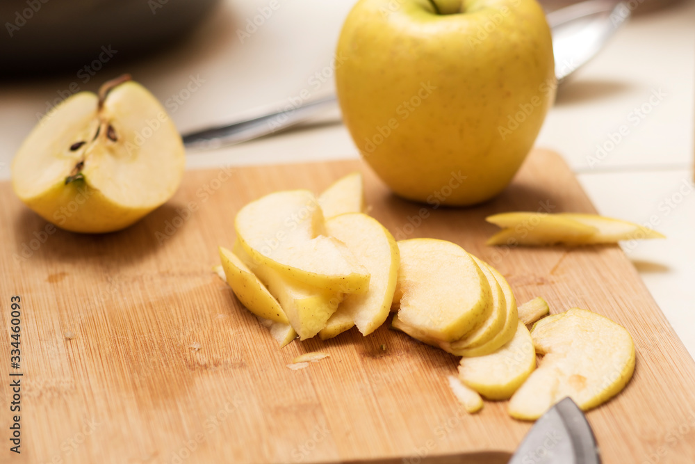 Female hands slicing apple cutting board