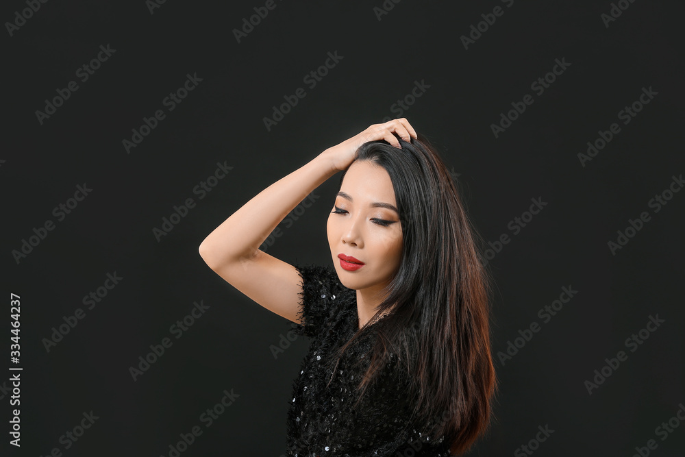 Young Asian woman with beautiful hair on dark background Young Asian woman with beautiful hair on dark background