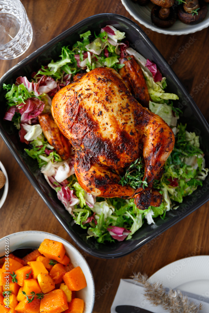 Top view of decorated festive table with whole roasted chicken, salad, pumpkin and mushrooms. The concept of family dinner or Thanksgiving celebrate. Top view of decorated festive table with whole roasted chicken, salad, pumpkin and mushrooms. The concept of family dinner or Thanksgiving celebrate.
