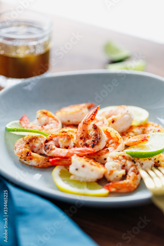 Fried tiger shrimp with lime, lemon and spices on a ceramic dish. Healthy dinner or lunch concept.
