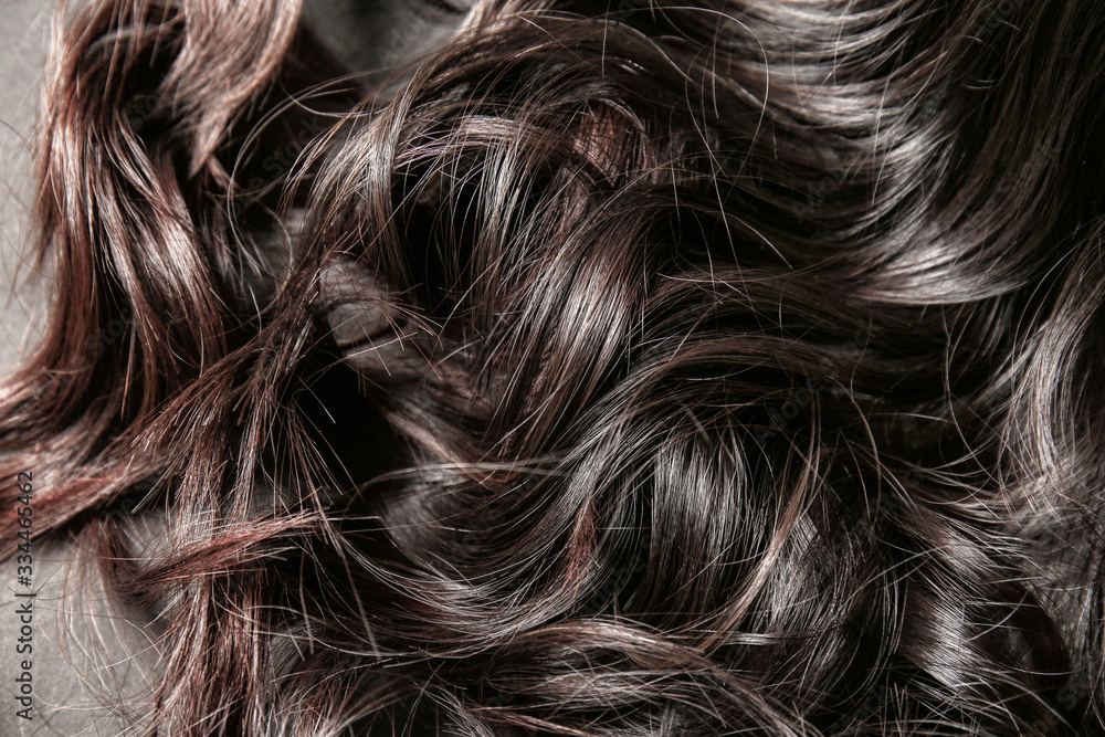 Curly female hair on dark background, closeup Curly female hair on dark background, closeup