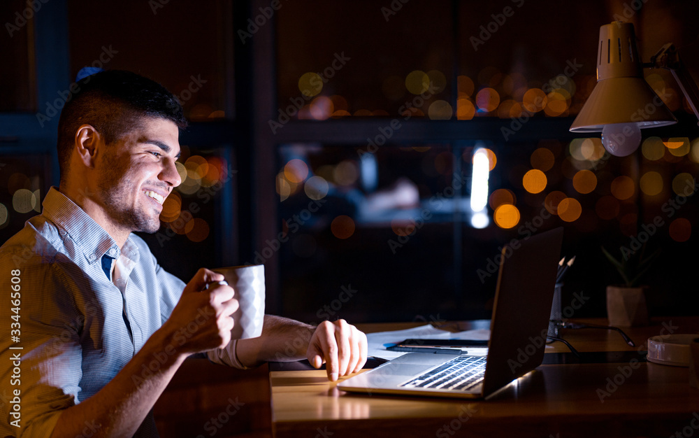 Happy Entrepreneur Sitting At Laptop Having Coffee At Workplace