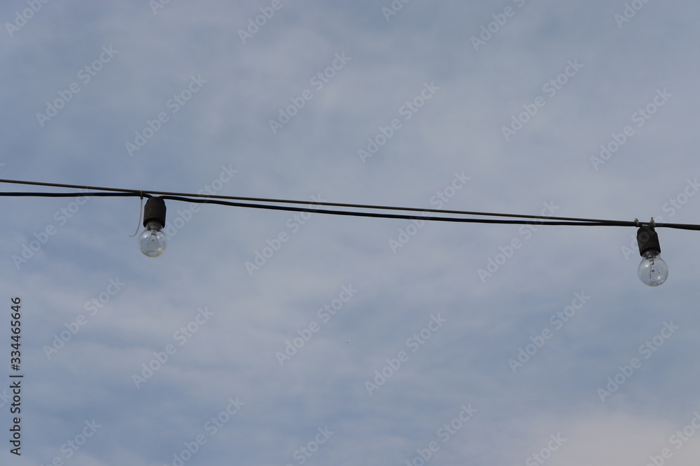 light bulb hanging on cable at street light bulb hanging on cable at street