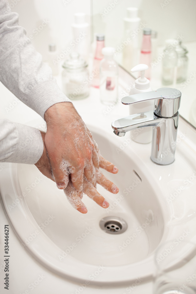 man washing hands with soap at home. coronavirus prevention hand hygiene man washing hands with soap at home. coronavirus prevention hand hygiene