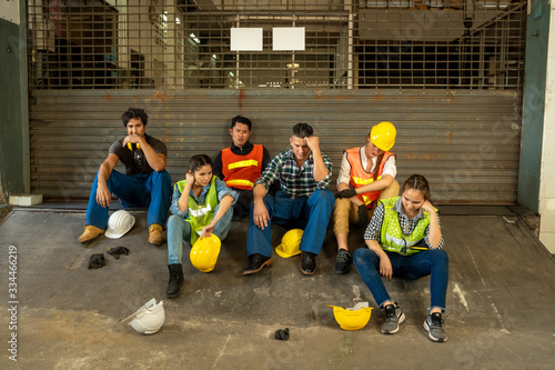 Group of Engineer unemployed from company sitting sad in factory After receiving news about factory closures because Coronavirus Disease 2019 (COVID-19).