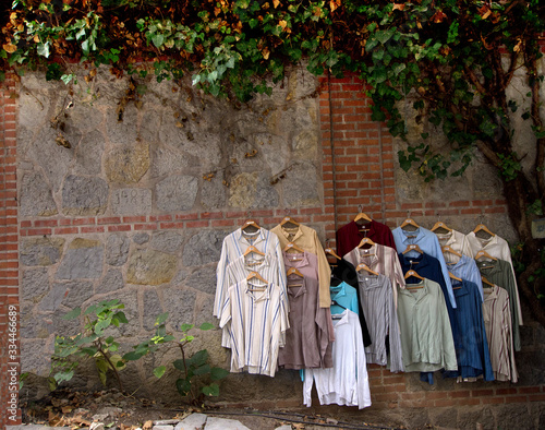 Hang colorful blouses outside on the beautiful wall for sale