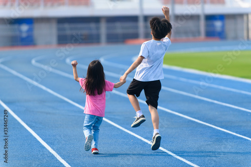 Young boy and girl play on a bluetrack after running