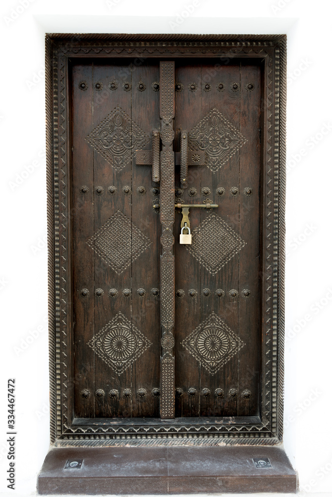 Tradiational carved wooden Arab doorway of a restored house in Muharraq, Bahrain.