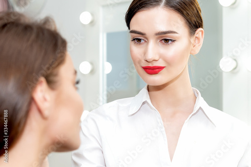 Makeup artist looks on client ready to work with client.