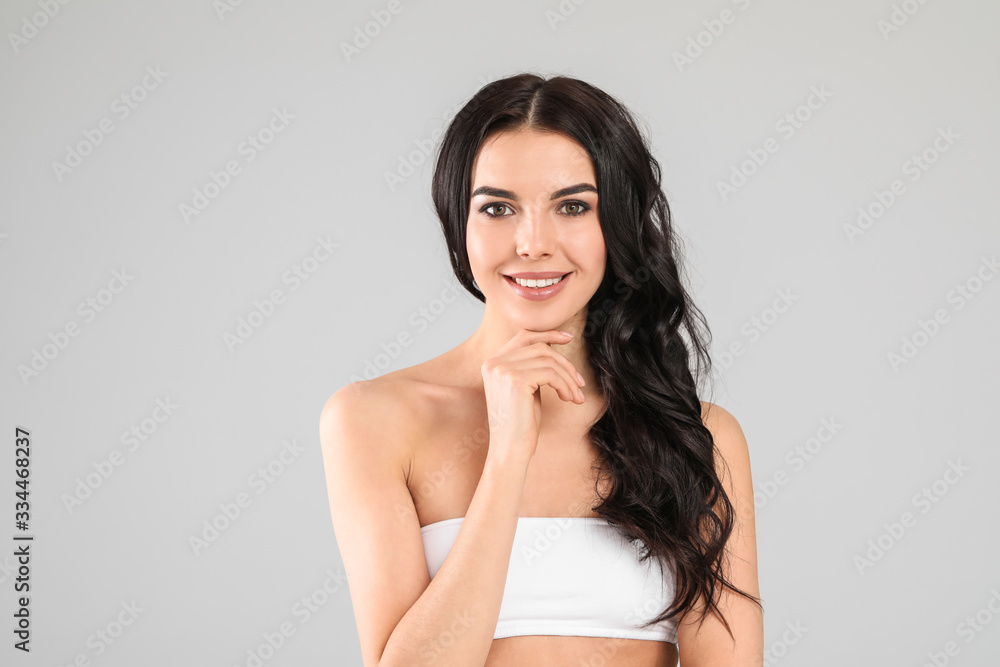 Young woman with beautiful healthy hair on grey background Young woman with beautiful healthy hair on grey background