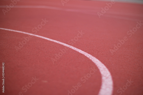 White line on a red rubber cover on an outdoor basketball court © PatriksPauls