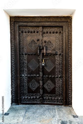 Tradiational carved wooden Arab doorway of a restored house in Muharraq, Bahrain. photo