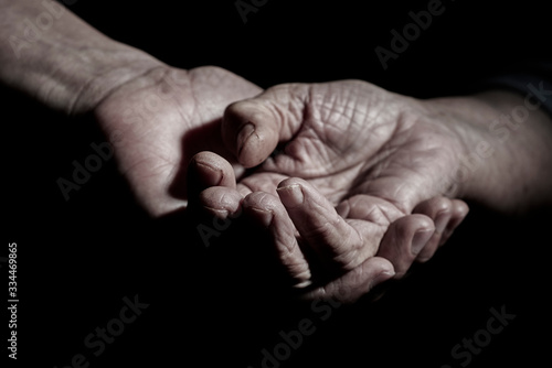 Tableau sur toile young man holding the hand of a senior woman