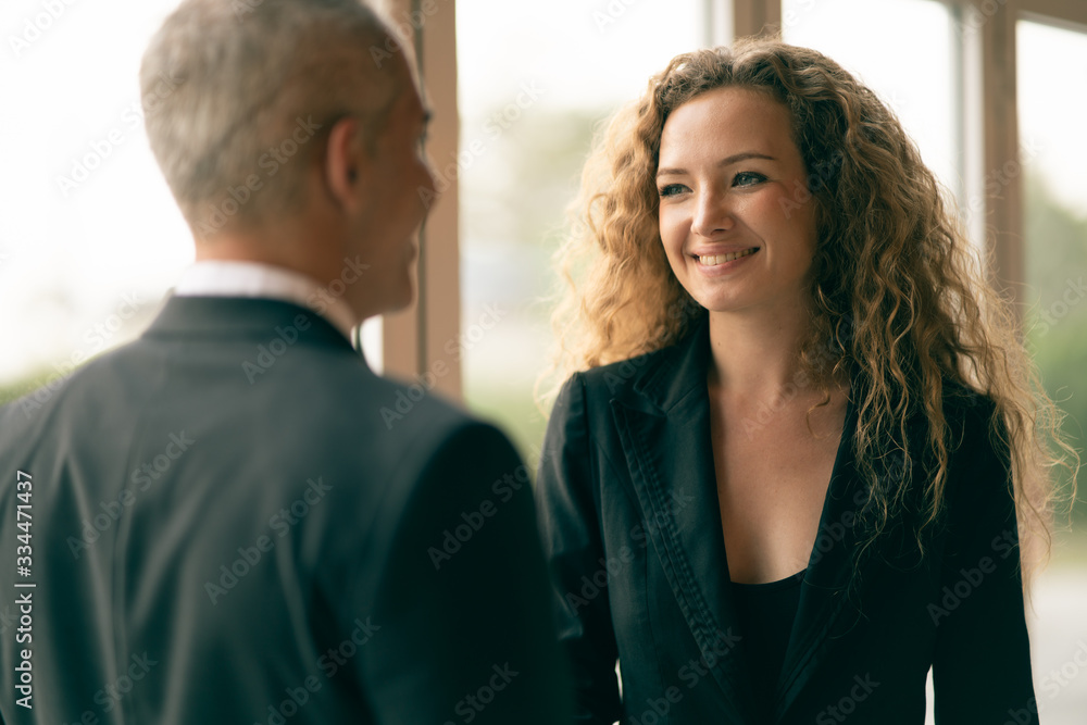 Gorgeous Caucasian businesswoman smiling with confidence, having handshake with businessman as foreground, concept of business greeting, congratulate business plan, business recruitment, woman at work Gorgeous Caucasian businesswoman smiling with confidence, having handshake with businessman as foreground, concept of business greeting, congratulate business plan, business recruitment, woman at work